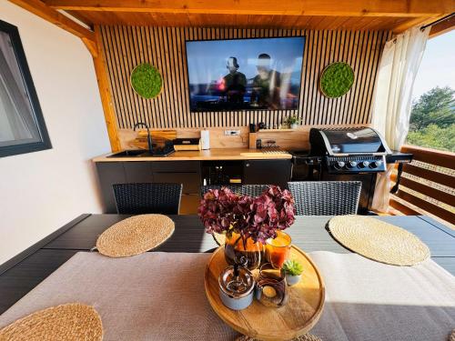 a dining room with a table and a television at Serenity Mobile House in Drage