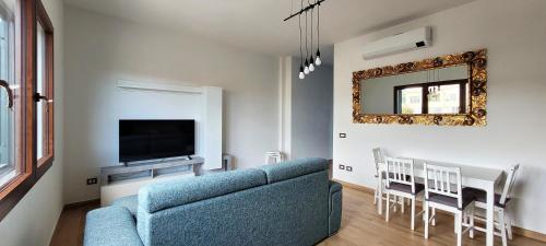 a living room with a blue couch and a television at Casa Nue - Appartamento Deluxe in Posada