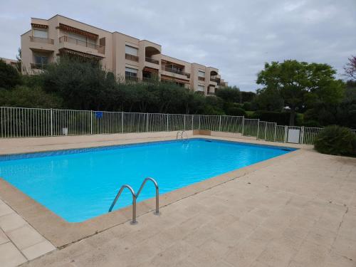 une grande piscine bleue devant un immeuble dans l'établissement Antibes La Louisiane 2 Pieces rez-de-jardin Piscine, à Antibes