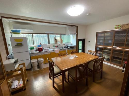 a kitchen with a table and chairs and a refrigerator at 宿坊宝塔寺 蓮Ren in Yoshino