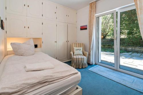 a bedroom with a bed and a chair and a window at Ferienwohnungen am Gunzenbach in Baden-Baden