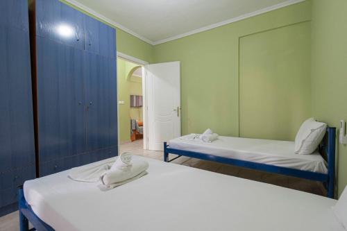 a room with two beds and a mirror at Minty Home by RentalsPro - Nea Flogita Halkidiki in Flogita