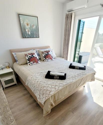 a bedroom with a bed with two towels on it at PJ's Apartment, Paphos, Cyprus in Khlorakas
