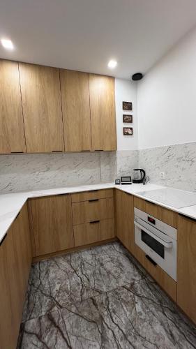 a kitchen with wooden cabinets and a sink at NEW Apartament BLACK Warszawa Parking FREE in Wola Mrokowska
