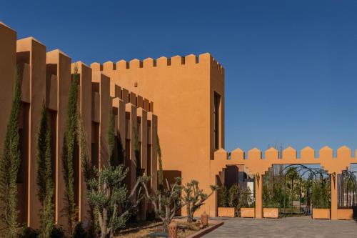 ein Backsteingebäude mit Bäumen davor in der Unterkunft Yin Hotel & Spa in Marrakesch