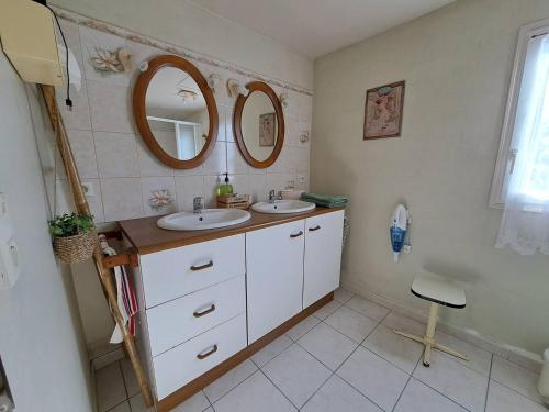 une salle de bain avec deux lavabos et un miroir dans l'établissement Refuge Champêtre, à Mézos