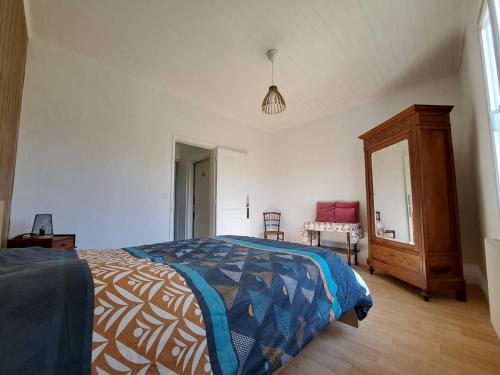 une chambre avec un lit, une commode et un miroir dans l'établissement Refuge Champêtre, à Mézos