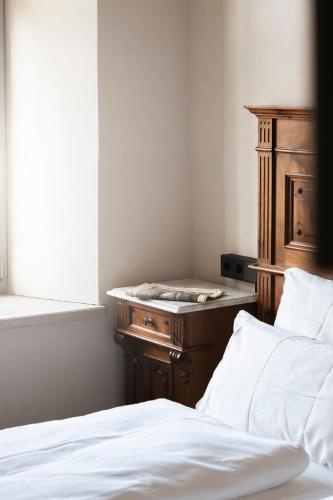a bedroom with a bed and a dresser and a window at Ansitz Thierburg Suites in Merano