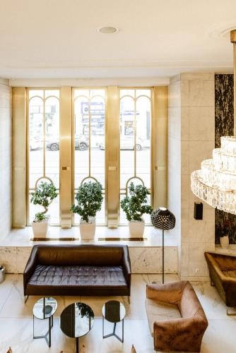 a lobby with a couch and chairs and windows at Hotel City Central in Vienna