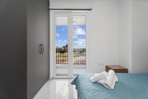 a bedroom with a bed and a sliding glass door at Modern 2BR Apartment Near Ayia Napa - Anastasia 104 in Xylophaghou