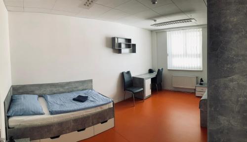a bedroom with a bed and a desk in it at Hotel Astorka in Brno