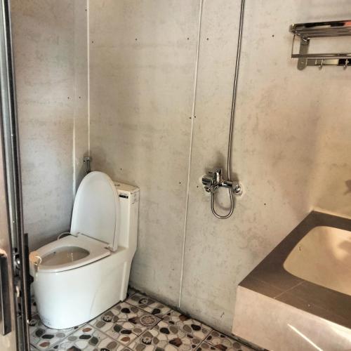 a bathroom with a toilet and a sink at Mường Sang Retreat in Mộc Châu