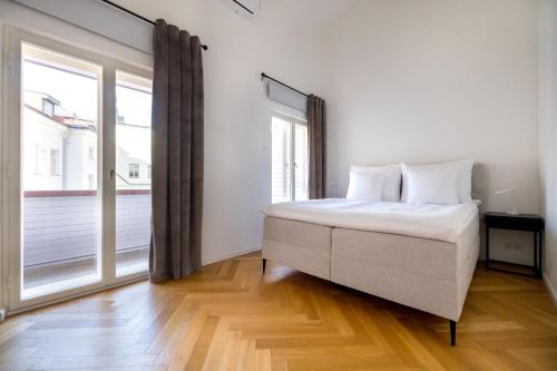 a white bedroom with a bed and a large window at Hestia Hotel Barons Old Town in Tallinn