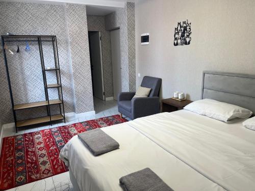 a hotel room with a bed and a chair at 77/5 in Chişinău