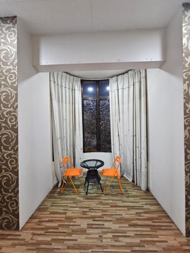 a room with two orange chairs and a table at Warni Villa 197 Whole Or Room in Muar