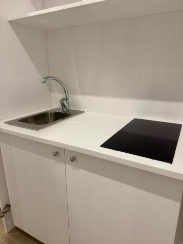 a white kitchen with a sink and a counter at Sorrento Bay Apartment in Sorrento