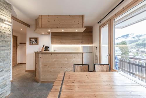 une cuisine et une salle à manger avec une grande fenêtre dans l'établissement Appartement au centre de megève, à Megève