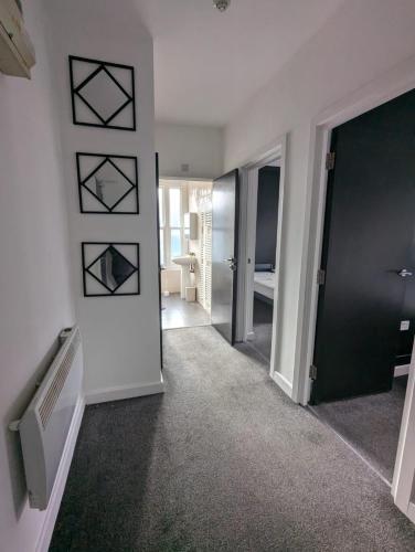 an empty room with a hallway with a door and a room with at Belvoir Bank central apartment with parking in Coalville