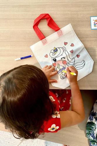 a little girl is painting a hello kitty drawing at Crowne Plaza Phu Quoc Starbay by IHG in Phu Quoc