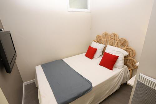 - une petite chambre avec un lit et des oreillers rouges dans l'établissement Appart T2 cosy a 5 minutes des plages !, à Latour-Bas-Elne