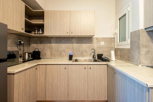 a kitchen with wooden cabinets and a sink at Aris123 by Smart Cozy Suites - Apartments in the heart of Athens - 5 minutes from metro - Available 24hr in Athens