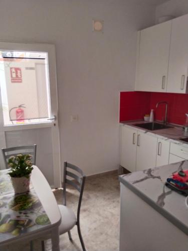 a kitchen with a table and a sink and a counter top at Los Eucaliptos in Fasnia