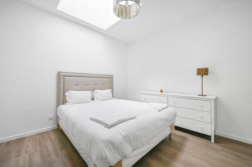 une chambre blanche avec un lit et une commode dans l'établissement La Familia - 5 pers - Jardin - Wifi, à Évreux