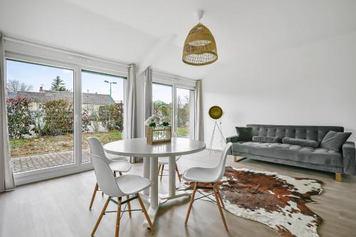 un salon avec une table, des chaises et un canapé dans l'établissement La Familia - 5 pers - Jardin - Wifi, à Évreux