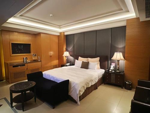a hotel room with a bed and a chair at Merry Day Motel Zhonghe Branch in Zhonghe