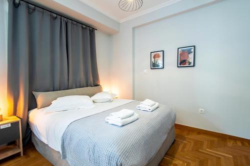 a bedroom with a bed with two towels on it at Aris123 by Smart Cozy Suites - Apartments in the heart of Athens - 5 minutes from metro - Available 24hr in Athens