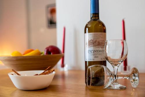 a bottle of wine and a glass on a table at Aris123 by Smart Cozy Suites - Apartments in the heart of Athens - 5 minutes from metro - Available 24hr in Athens