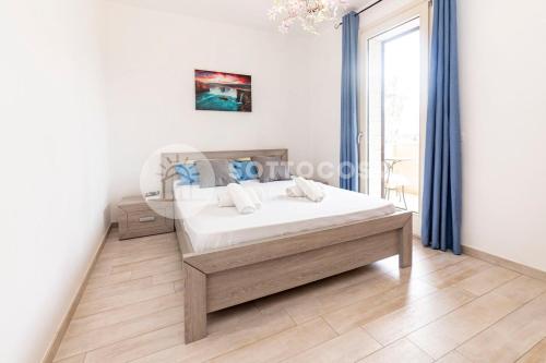 Schlafzimmer mit einem Bett mit blauen Vorhängen in der Unterkunft Oasi delle Meraviglie in Torre dell'Orso