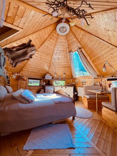 - une chambre avec un grand lit au plafond en bois dans l'établissement Cabane, Kota Désiré, à Saint-Dié-des-Vosges