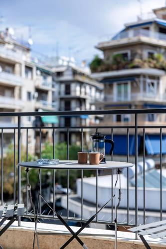 a table with a tea kettle and two cups on a balcony at Aris123 by Smart Cozy Suites - Apartments in the heart of Athens - 5 minutes from metro - Available 24hr in Athens