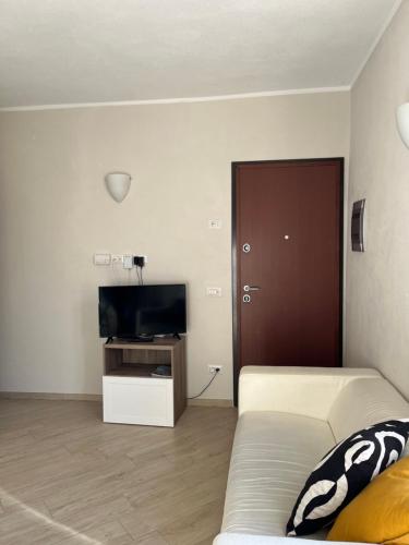 a living room with a couch and a flat screen tv at Appartamento in pieno centro a tre minuti dalla spiaggia in Finale Ligure