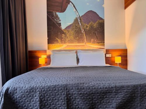 a bedroom with a bed with a painting on the wall at Hotel Spirodom in Admont