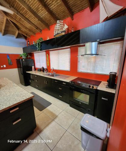 a kitchen with red walls and black cabinets at Carolina Point Resort in Crown Point