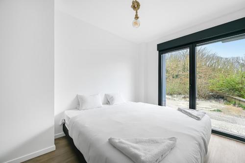 une chambre blanche avec un grand lit et une fenêtre dans l'établissement Evreux - Le Blue - Love Room - 2 people - Wi-Fi, à Évreux