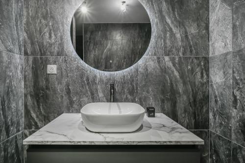 une salle de bain avec un lavabo et un miroir dans l'établissement Evreux - Le Blue - Love Room - 2 people - Wi-Fi, à Évreux