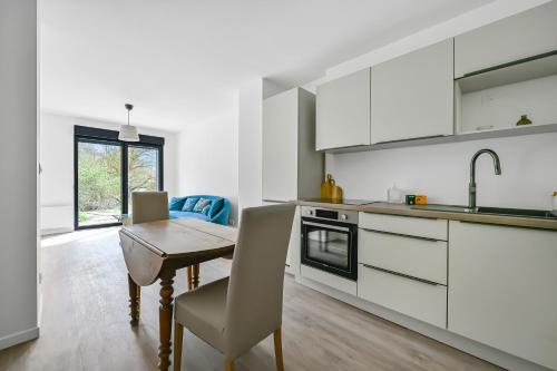 une cuisine avec des armoires blanches et une table en bois dans l'établissement Evreux - Le Blue - Love Room - 2 people - Wi-Fi, à Évreux