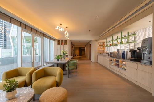 a large kitchen with yellow chairs and a table at 采寓halo house in Taichung