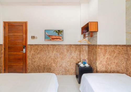 a hotel room with two beds and a door at Khách sạn gần biển Viva Tuy Hoà Phú Yên in Phường Sáu