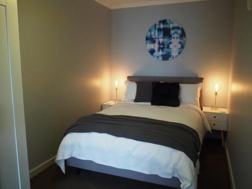 a bedroom with a large bed with two lamps at City Quarters on Brewer in Perth