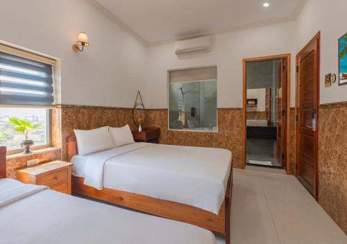 a bedroom with two beds and a window at Khách sạn gần biển Viva Tuy Hoà Phú Yên in Phường Sáu