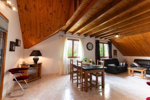 - un salon avec des plafonds en bois, une table et des chaises dans l'établissement La barrina, à Saint-Sauveur-de-Peyre