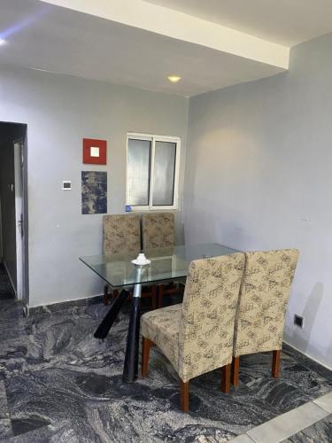 a dining room with a glass table and chairs at Romeo Court in Akure