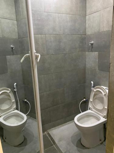 a bathroom with two toilets in a stall at Romeo Court in Akure