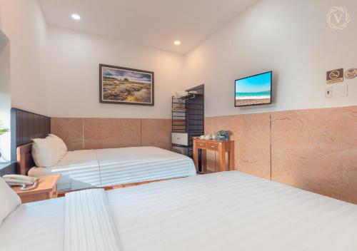 a hotel room with two beds and a tv at Khách sạn gần biển Viva Tuy Hoà Phú Yên in Phường Sáu