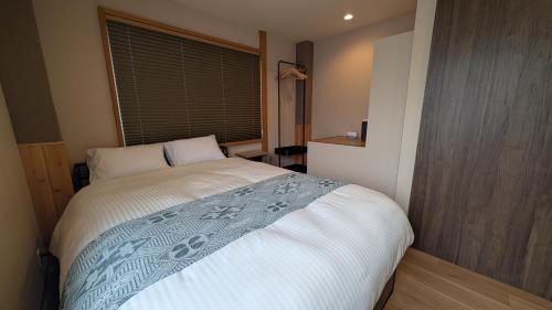 a bedroom with a large bed with a window at Dream Stays TSUKI in Osaka