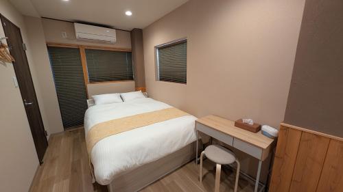 a small bedroom with a bed and a desk at Dream Stays TSUKI in Osaka